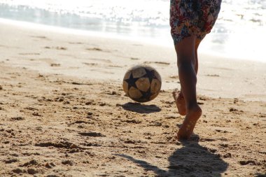 Kumsalda futbol oynayan insanların bacaklarına bakın. 