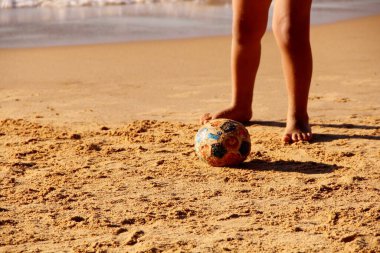Kumsalda futbol oynayan insanların bacaklarına bakın. 