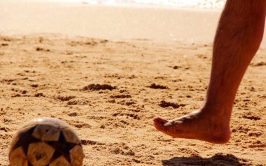 Kumsalda futbol oynayan insanların bacaklarına bakın. 