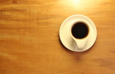 Ahşap arka planda bir fincan dolusu kahve manzarası