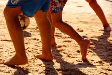 Kumsalda futbol oynayan insanların bacaklarına bakın. 