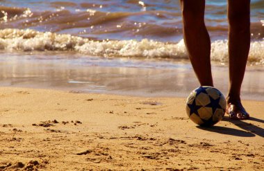 Kumsalda futbol oynayan insanların bacaklarına bakın. 