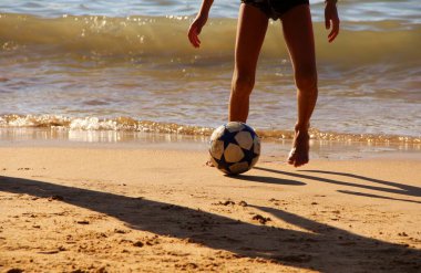 Kumsalda futbol oynayan insanların bacaklarına bakın. 