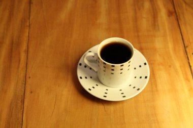 Ahşap arka planda bir fincan dolusu kahve manzarası