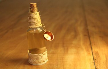 Ahşap zemin üzerinde sıvı bulunan mantarlı şişe görüntüsü