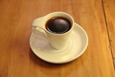 Ahşap arka planda bir fincan dolusu kahve manzarası