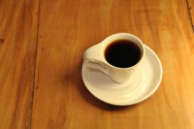 Ahşap arka planda bir fincan dolusu kahve manzarası