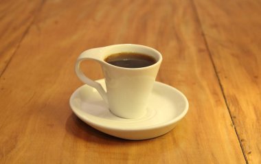 Ahşap arka planda bir fincan dolusu kahve manzarası