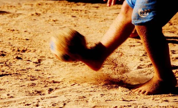 Kumsalda futbol oynayan insanların bacaklarına bakın. 