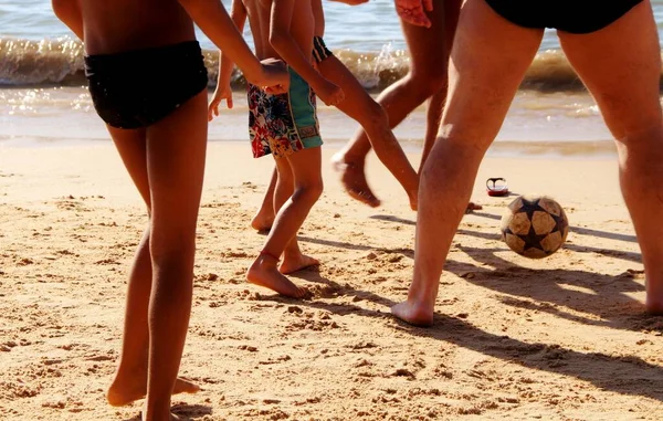 Kumsalda futbol oynayan insanların bacaklarına bakın. 
