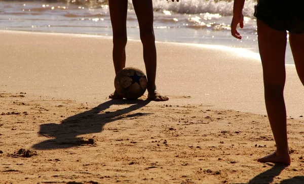 Kumsalda futbol oynayan insanların bacaklarına bakın. 