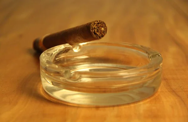 Closeup Άποψη Του Καπνίσματος Πούρο Ένα Γυάλινο Τασάκι Ξύλινο Φόντο — Φωτογραφία Αρχείου