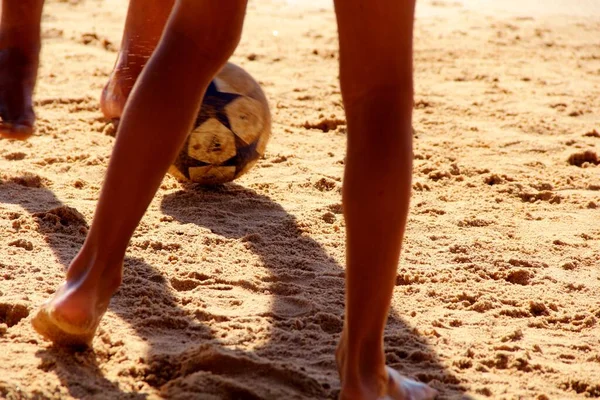 Kumsalda futbol oynayan insanların bacaklarına bakın. 