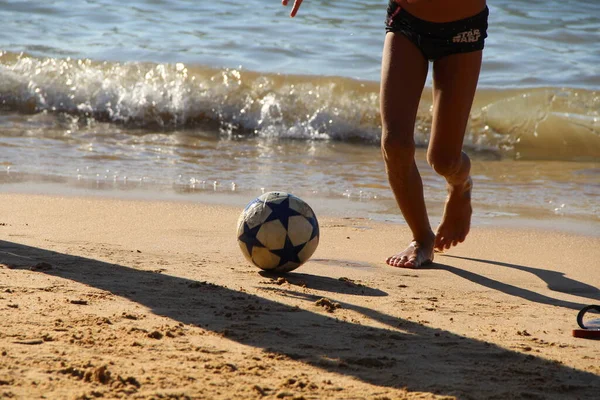 Kumsalda futbol oynayan insanların bacaklarına bakın. 