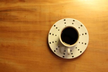 Ahşap arka planda bir fincan dolusu kahve manzarası