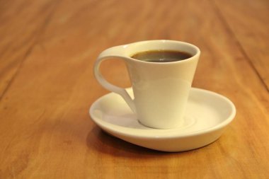 Ahşap arka planda bir fincan dolusu kahve manzarası