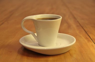 Ahşap arka planda bir fincan dolusu kahve manzarası