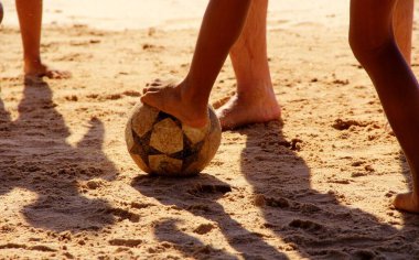 Kumsalda futbol oynayan insanların bacaklarına bakın. 