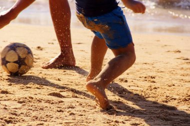 Kumsalda futbol oynayan insanların bacaklarına bakın. 