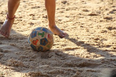 Kumsalda futbol oynayan insanların bacaklarına bakın. 