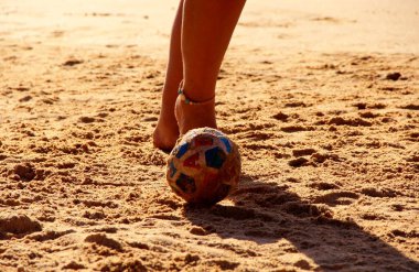 Kumsalda futbol oynayan insanların bacaklarına bakın. 