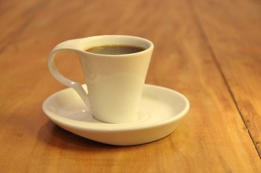 Ahşap arka planda bir fincan dolusu kahve manzarası