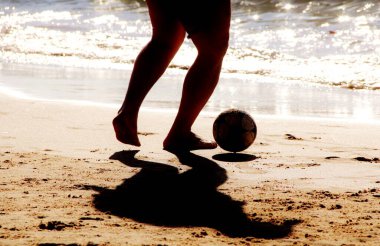 Kumsalda futbol oynayan insanların bacaklarına bakın. 