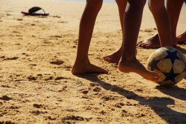 Kumsalda futbol oynayan insanların bacaklarına bakın. 