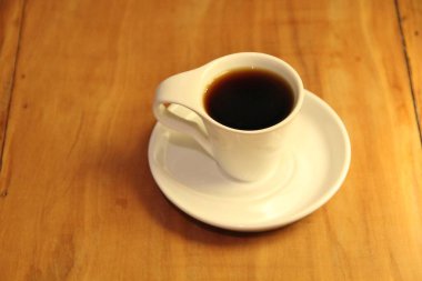 Ahşap arka planda bir fincan dolusu kahve manzarası