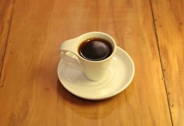 Ahşap arka planda bir fincan dolusu kahve manzarası