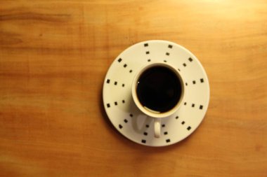 Ahşap arka planda bir fincan dolusu kahve manzarası