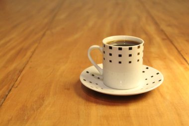 Ahşap arka planda bir fincan dolusu kahve manzarası