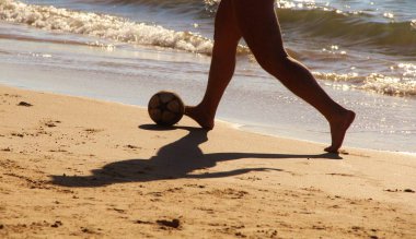 Kumsalda futbol oynayan insanların bacaklarına bakın. 