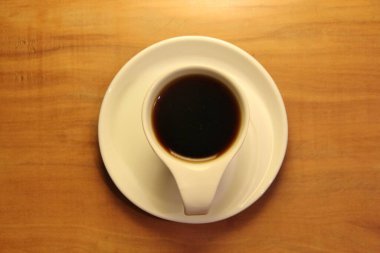 Ahşap arka planda bir fincan dolusu kahve manzarası