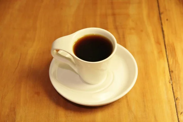 Άποψη Ενός Πλήρους Φλιτζανιού Καφέ Ένα Πιατάκι Ξύλινο Φόντο — Φωτογραφία Αρχείου