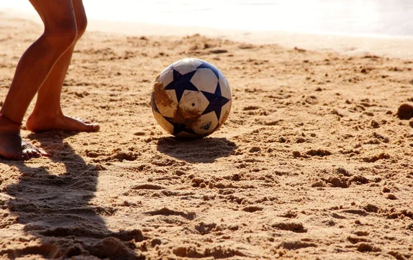 Kumsalda futbol oynayan insanların bacaklarına bakın. 