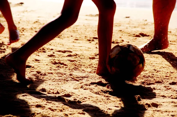 Kumsalda futbol oynayan insanların bacaklarına bakın. 