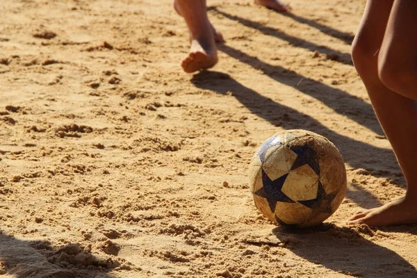 Kumsalda futbol oynayan insanların bacaklarına bakın. 