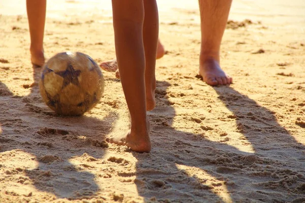 Kumsalda futbol oynayan insanların bacaklarına bakın. 