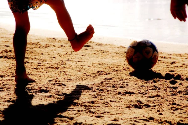 Kumsalda futbol oynayan insanların bacaklarına bakın. 