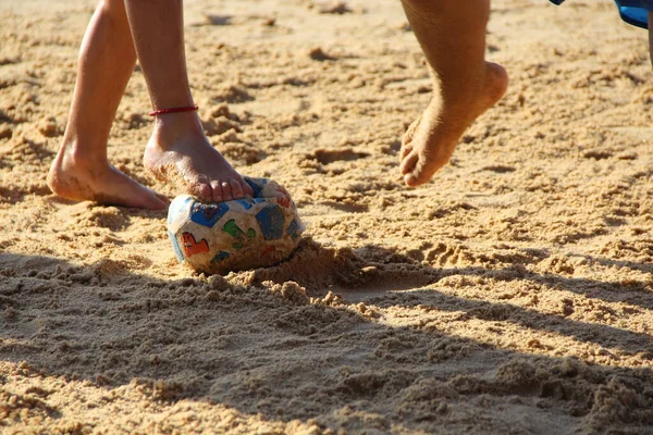 Kumsalda futbol oynayan insanların bacaklarına bakın. 