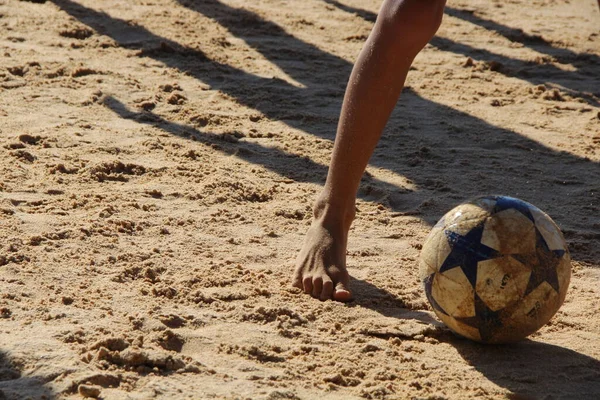 Kumsalda futbol oynayan insanların bacaklarına bakın. 