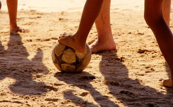 Kumsalda futbol oynayan insanların bacaklarına bakın. 