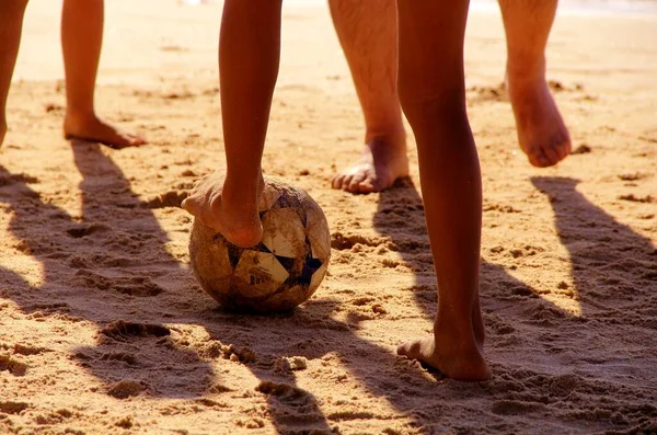 Kumsalda futbol oynayan insanların bacaklarına bakın. 