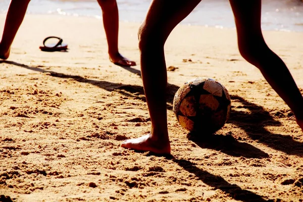 Kumsalda futbol oynayan insanların bacaklarına bakın. 