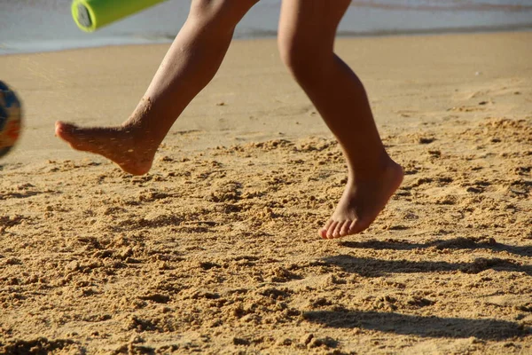 Kumsalda futbol oynayan insanların bacaklarına bakın. 