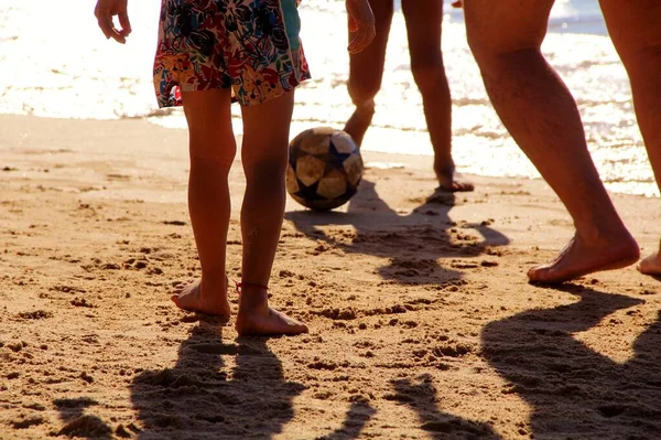 Kumsalda futbol oynayan insanların bacaklarına bakın. 