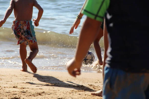 Kumsalda futbol oynayan insanların bacaklarına bakın. 