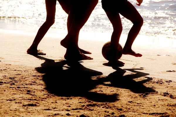 Kumsalda futbol oynayan insanların bacaklarına bakın. 