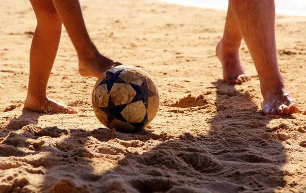 Kumsalda futbol oynayan insanların bacaklarına bakın. 